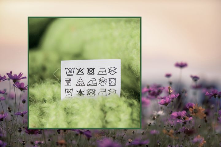 A laundry tag with symbols against a meadow background
