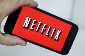 在这张图片中，Netflix媒体服务提供商的标志显示在智能手机的屏幕上＂width=