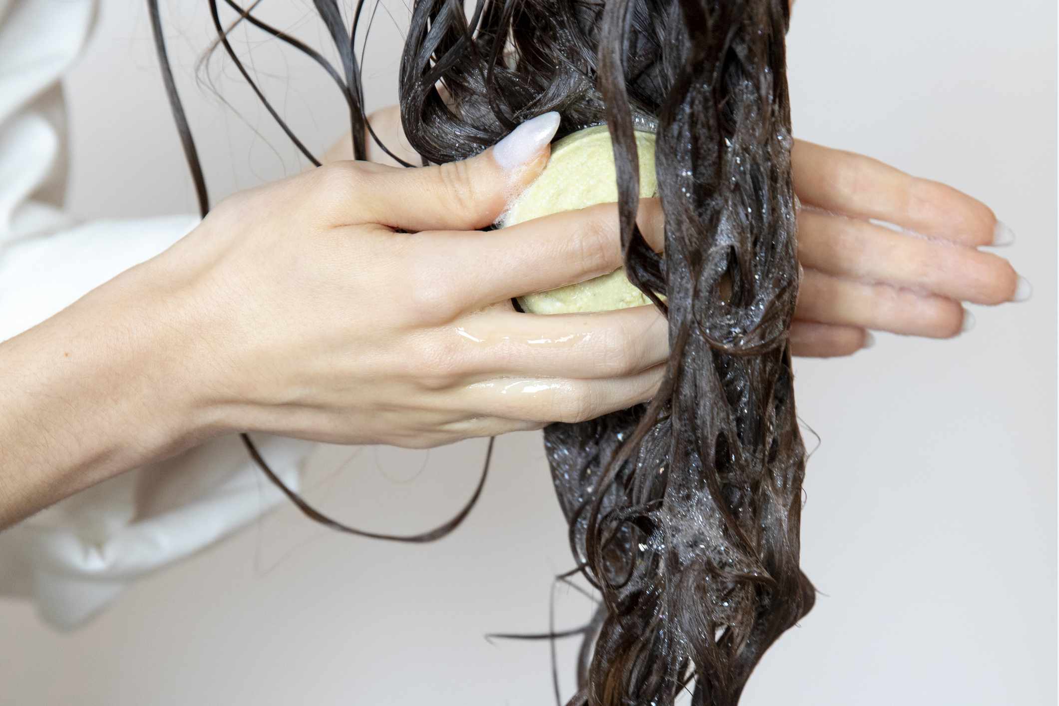 女人用固体肥皂洗头发与洗发水棒库存照片＂width=