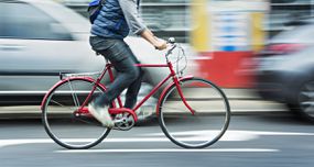 男子在街上骑着红色自行车骑自行车