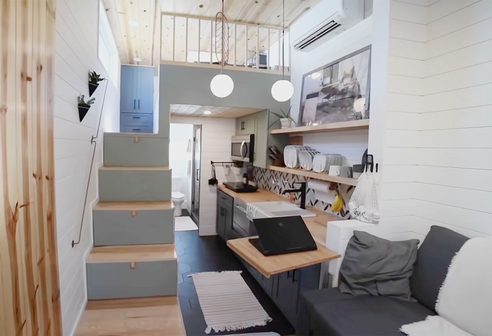Sydne Gold设计的一个小房子的内部图像，可以看到厨房和通往顶部的楼梯。