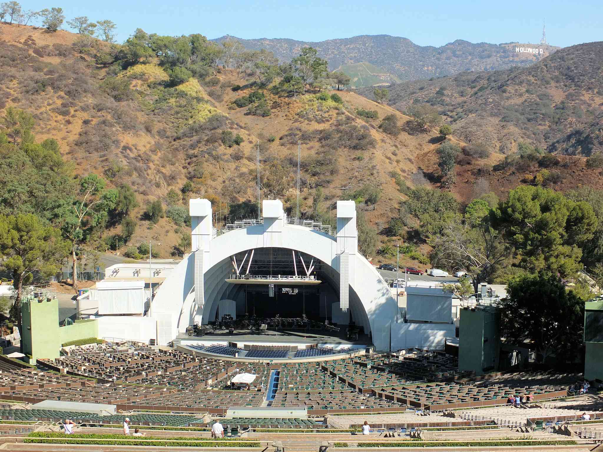 从座位区顶部俯瞰好莱坞露天剧场，以山脉和蓝天为背景