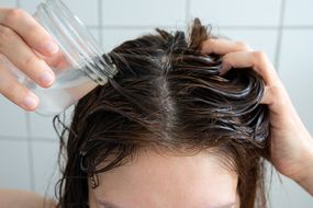 头顶的人在淋浴时用玻璃罐里的自制洗发水洗头发的照片