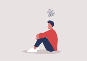 年轻的抑郁男性角色坐在地板上，抱着膝盖，一个卡通涂鸦在他们的头上，心理健康问题