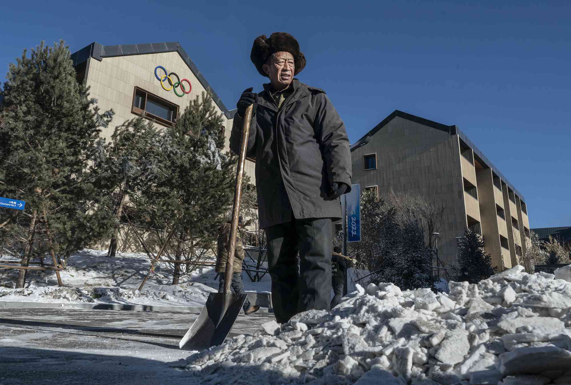 一名工人在北京2022奥运会领先的运动员村外面的人造雪