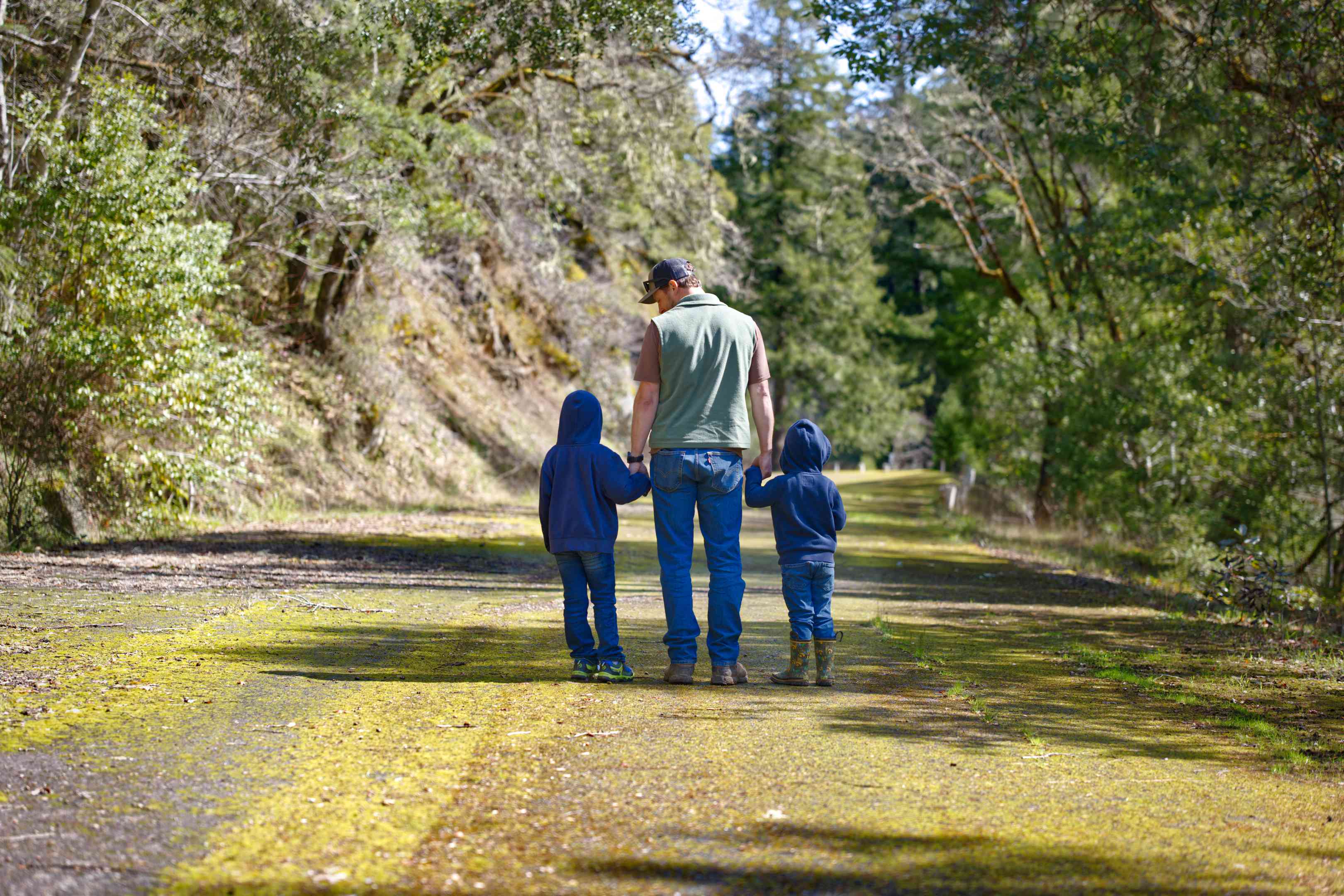 徒步旅行者和两个孩子在树林中耐用的地表道路上散步和远足“width=
