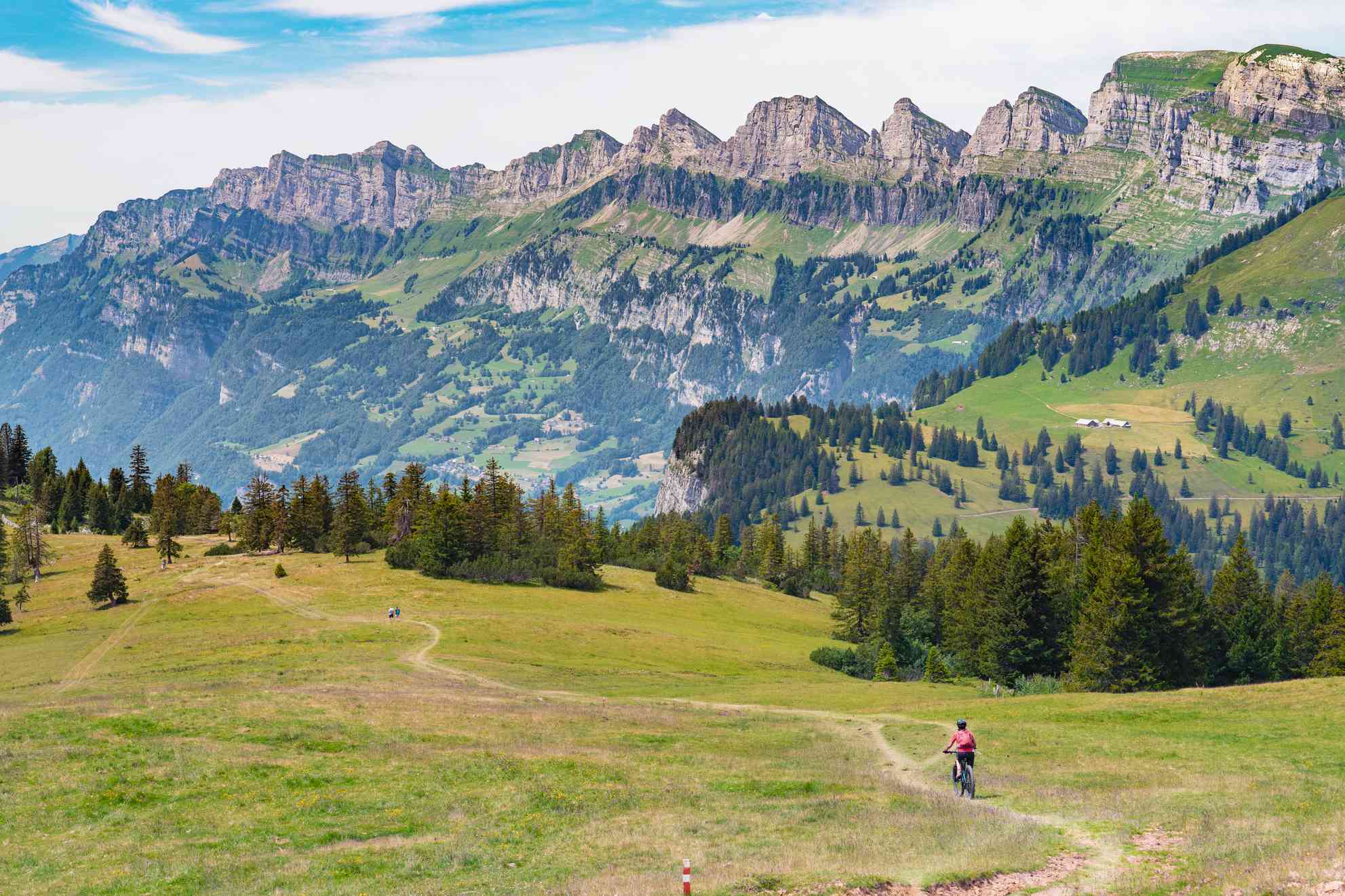 一名女子骑着山地车从阿尔卑斯山的一条小路上走下来