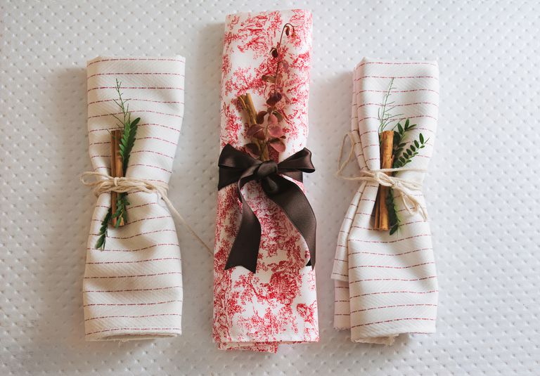 三个折叠的餐巾纸，带有假日圣诞节装饰和餐巾纸