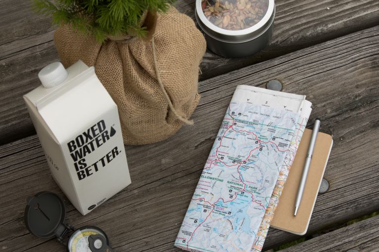 野餐桌上带有地图，盒装水的纸箱更好。