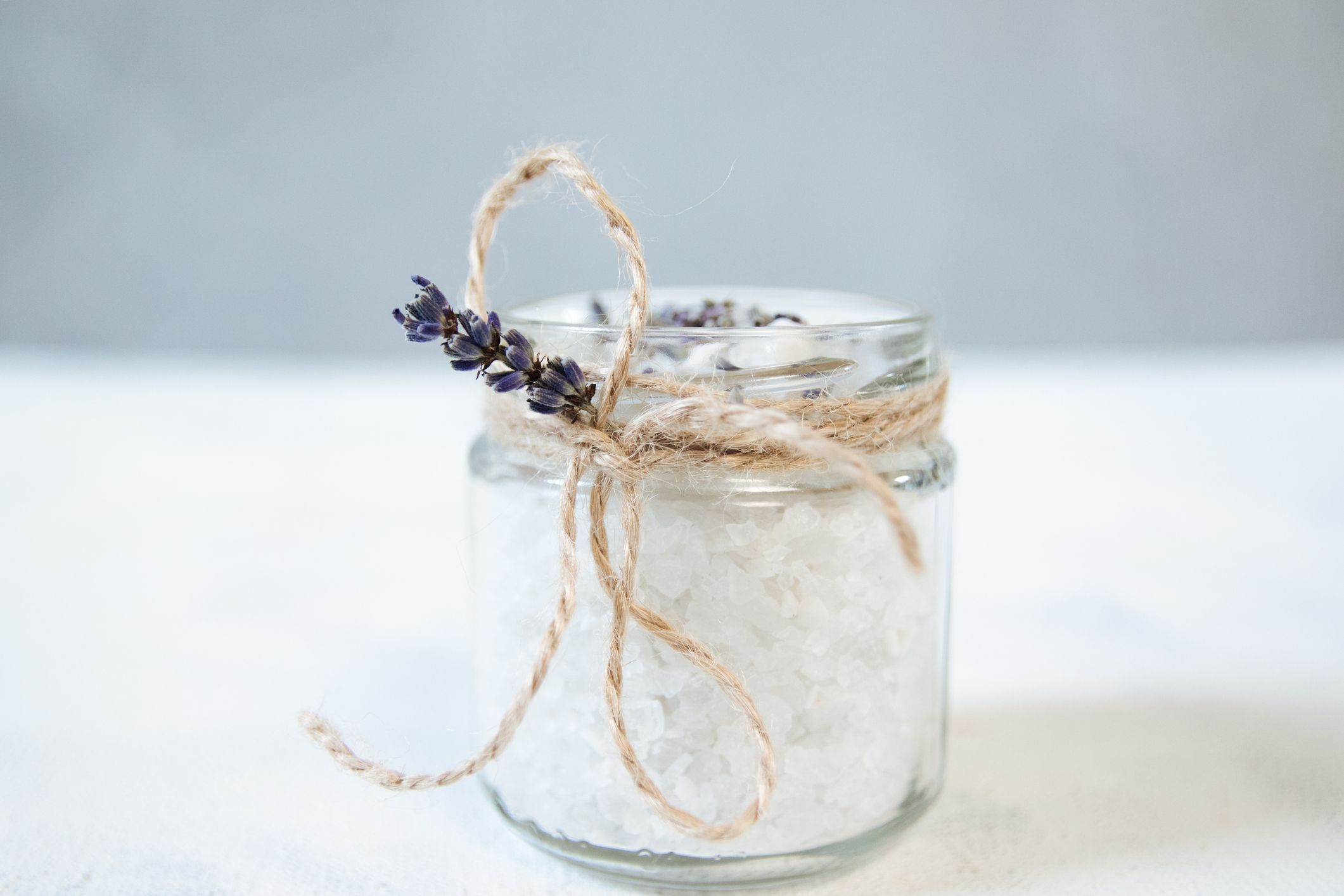 用麻绳和薰衣草系在玻璃罐里的泻盐。