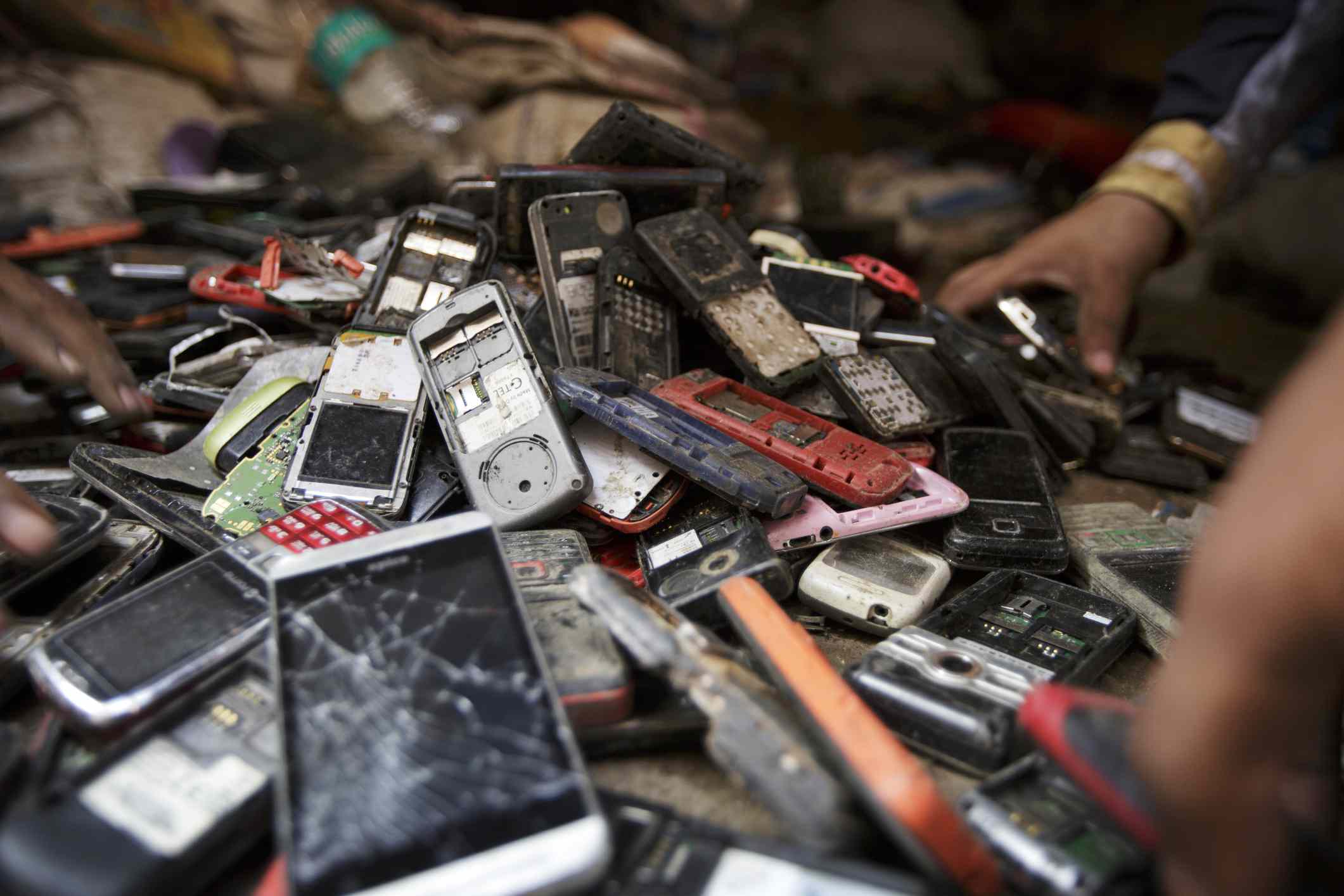 在印度新德里，工人们在整理一堆用过的手机