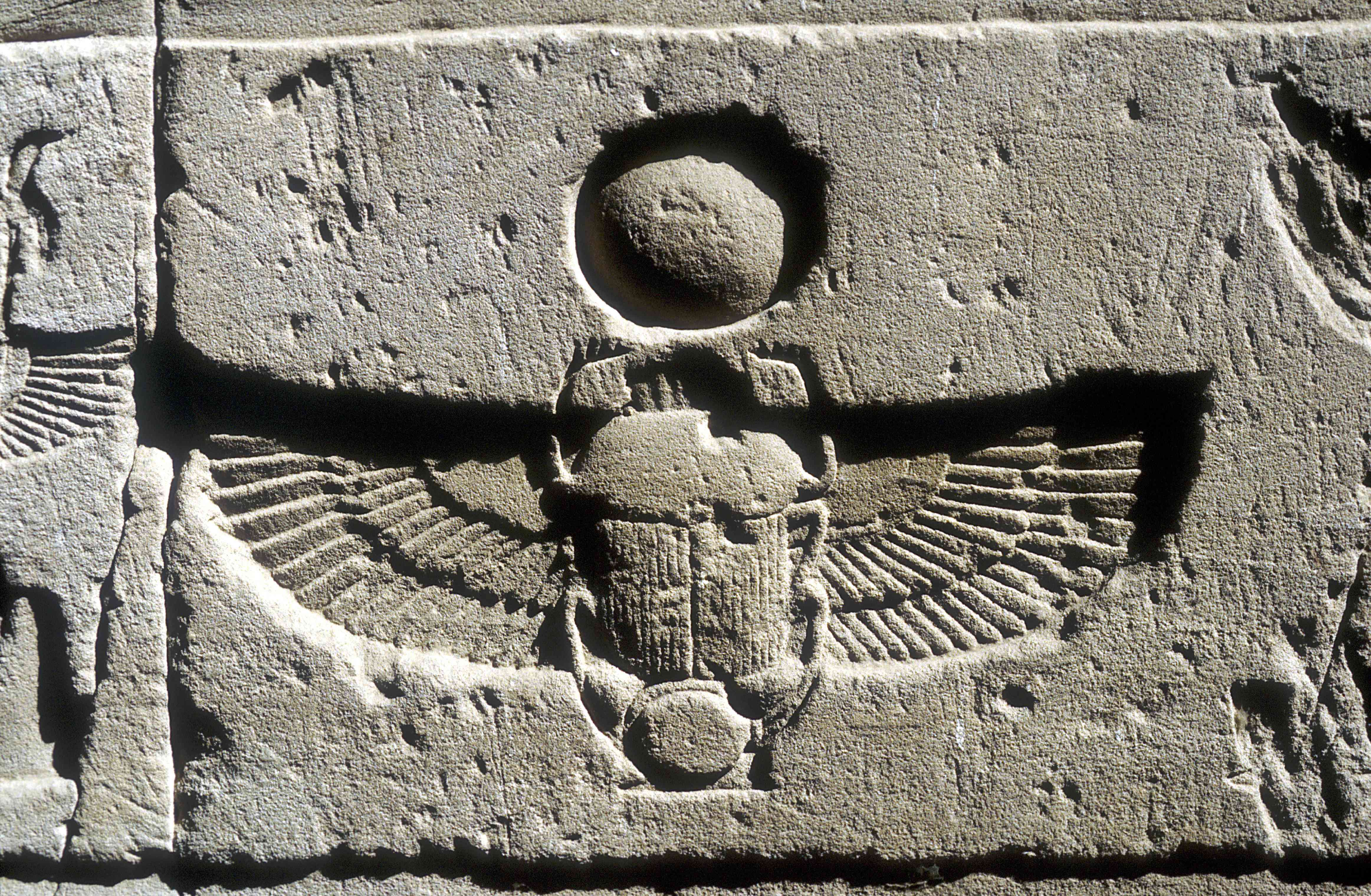 埃及Edfu，在太阳圆盘下刻有圣甲虫和秃鹫翅膀的石灰岩浮雕。