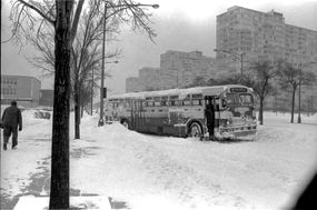 芝加哥交通管理局(CTA)巴士在冬季暴风雪期间在芝加哥，IL, 1967年1月沿途停靠。马车上悬挂着冰柱。＂width=