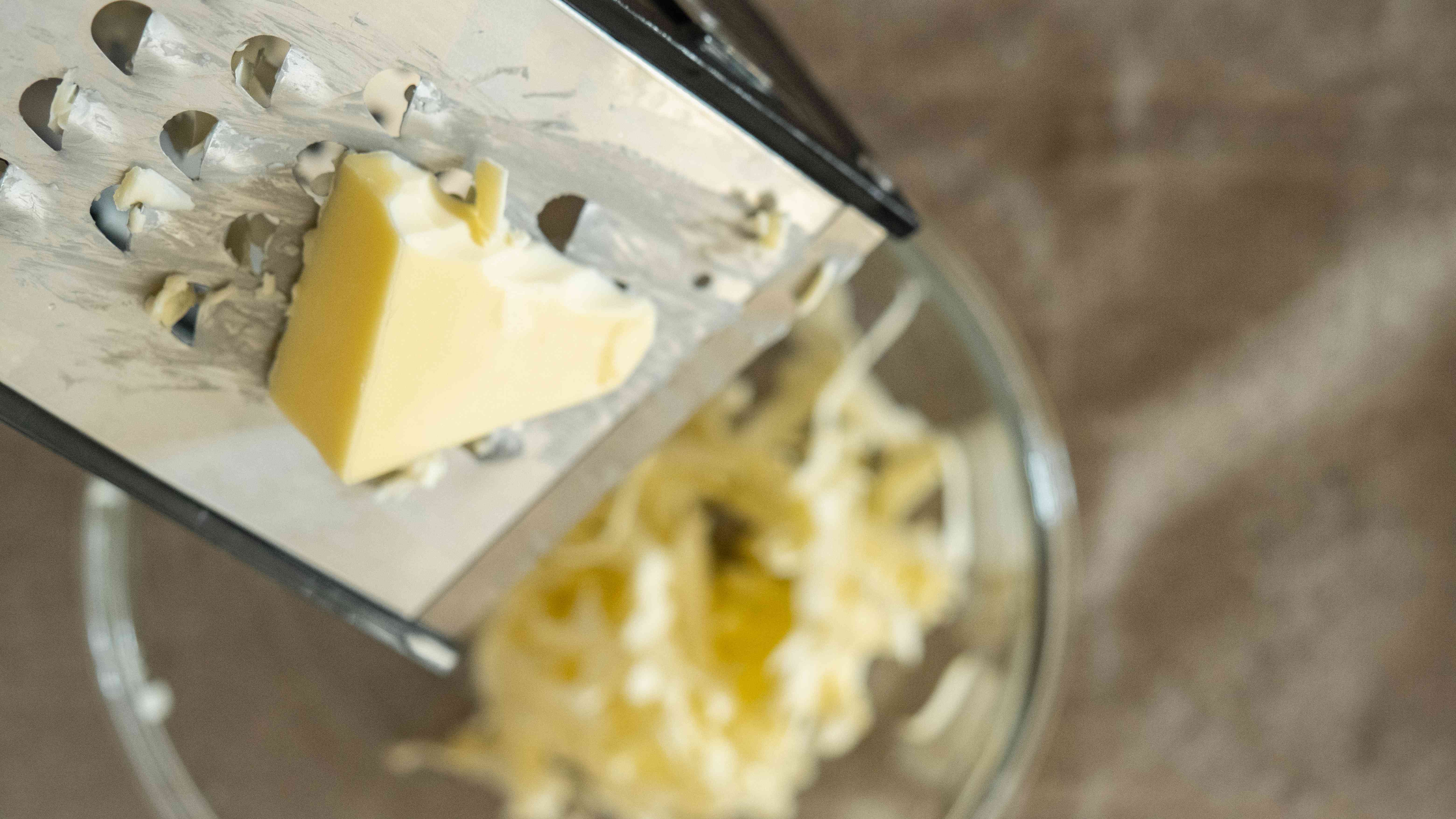 头顶近景:磨碎机将硬黄油切成玻璃碗