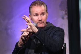 制片人摩根·斯普洛克（Morgan Spurlock）在舞台上与麦克风交谈。