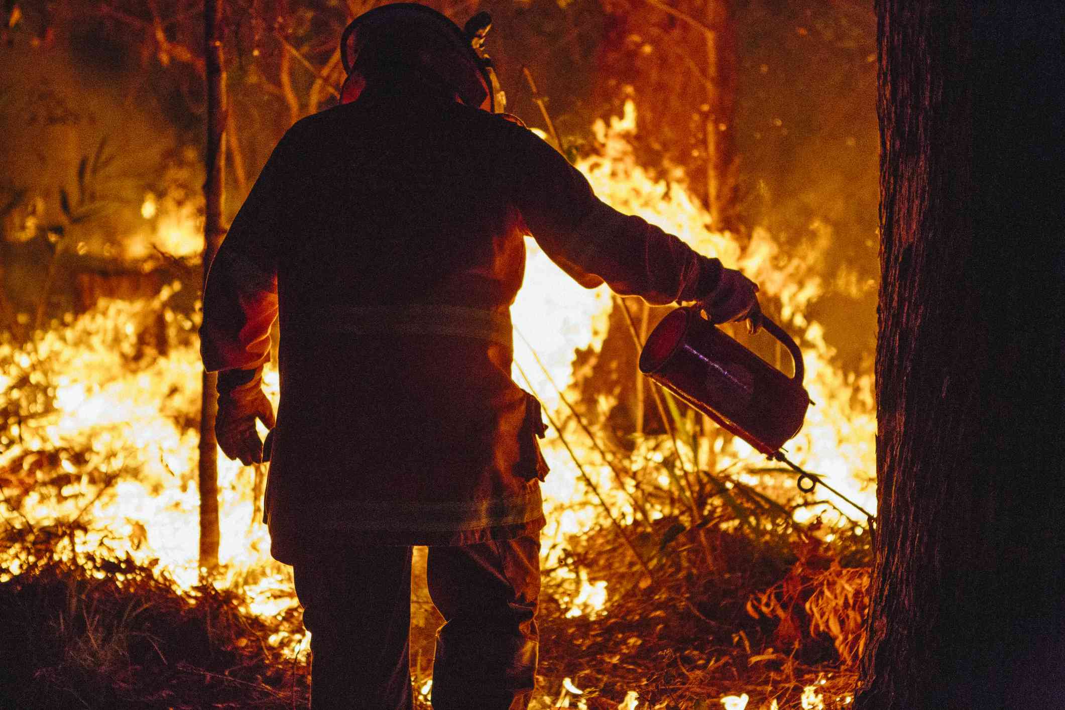 一名消防队员正在用滴漏式火炬进行控制燃烧