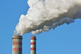 两个燃煤发电厂的大烟囱映衬着晴朗的天空。
