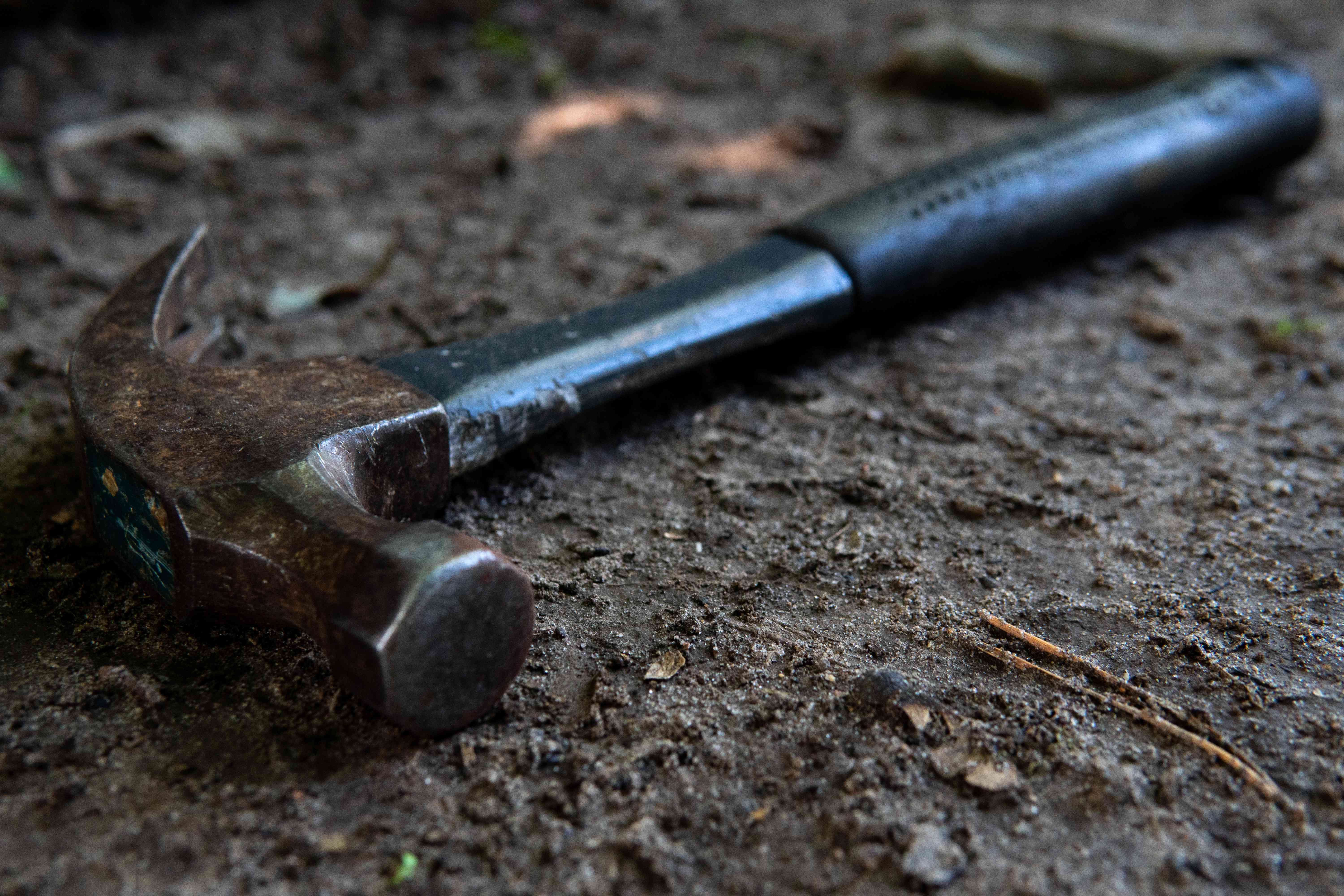 金属羊角锤搁在泥土地上