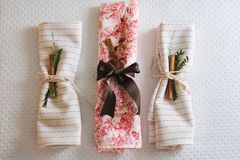 三个折叠的餐巾纸，带有假日圣诞节装饰和餐巾纸