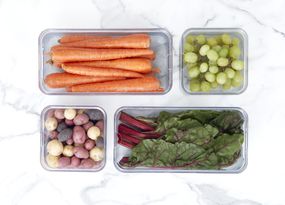 精选的水果和蔬菜在整洁的再生塑料储物箱中“width=