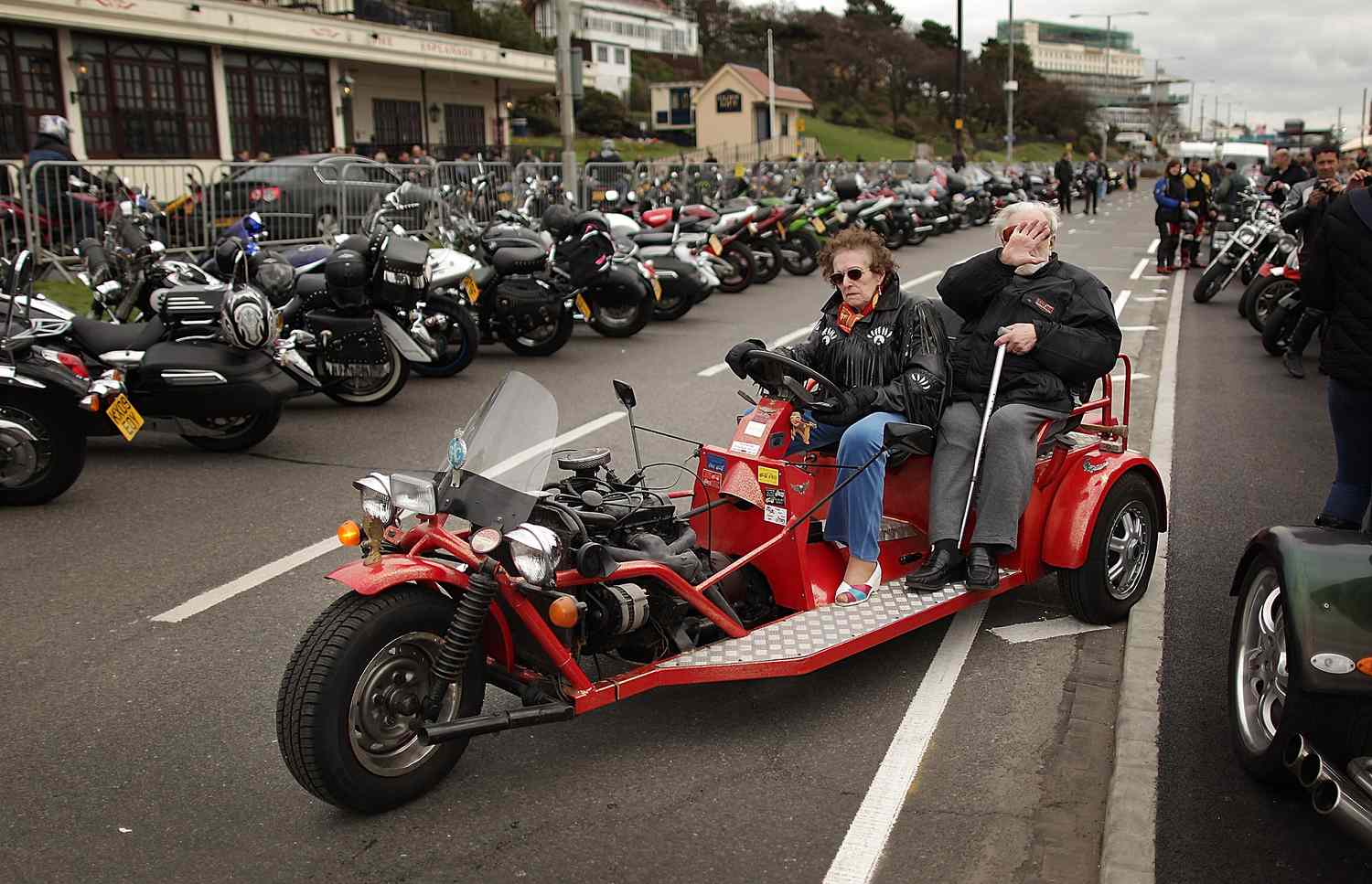 一对老夫妇骑着三个轮子的摩托车