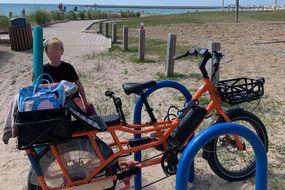 凯瑟琳在海滩上的电动自行车＂width=