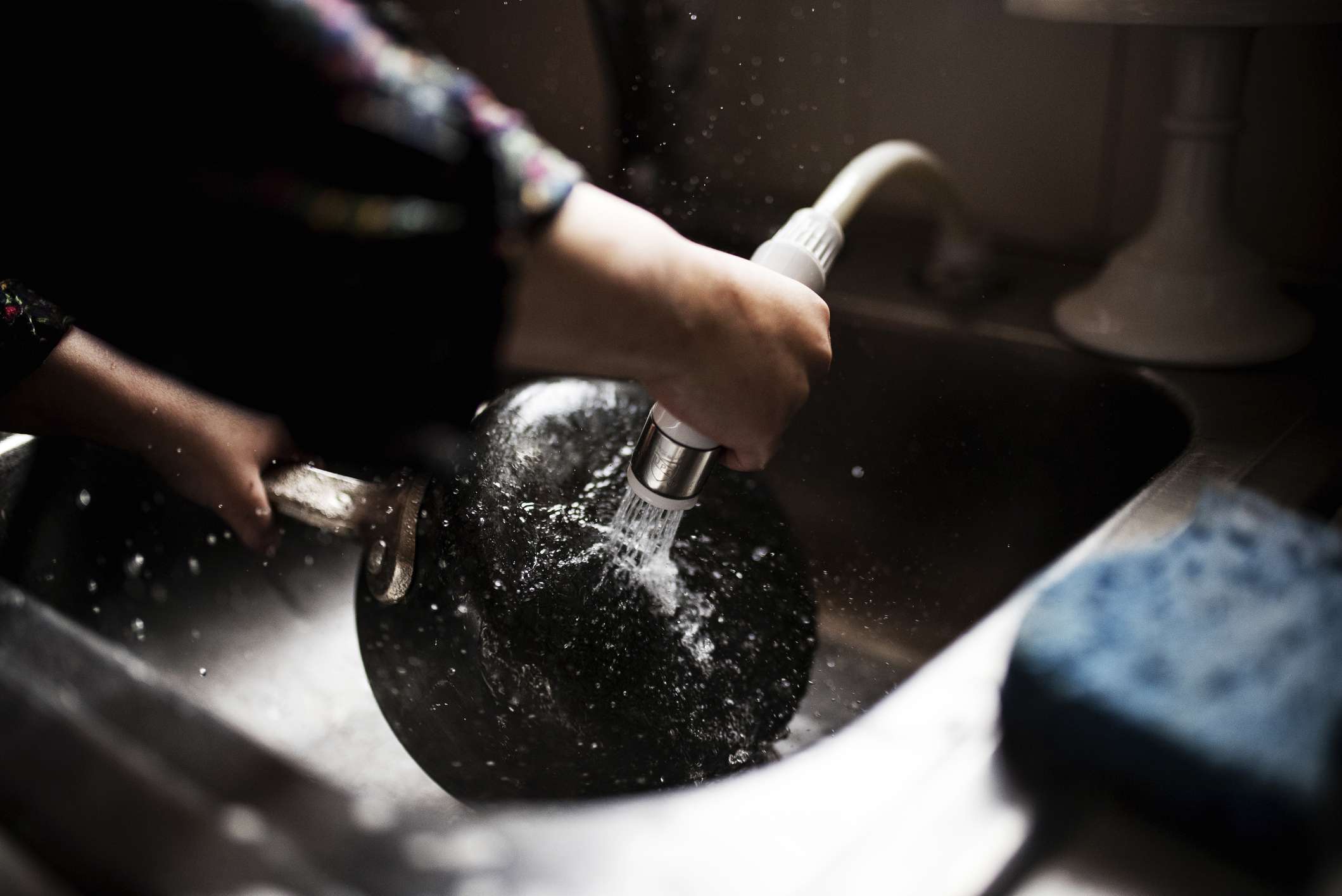 裁剪图像的女孩洗平底锅在厨房水槽