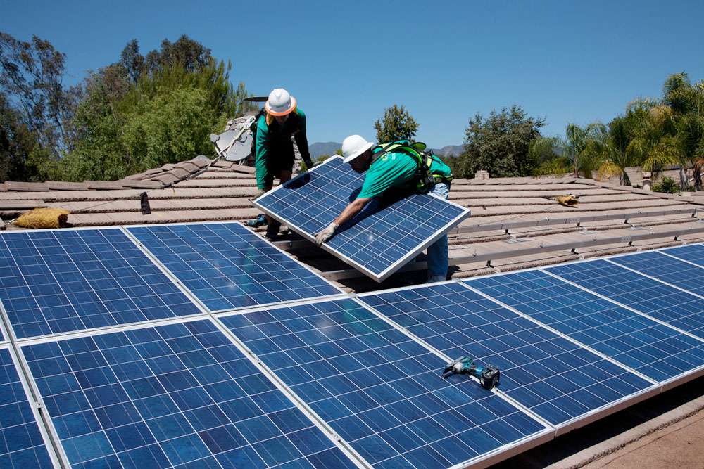 两名工人在南加州橡树景的家中安装太阳能电池板