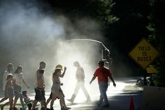 行人从2000年6月16日在加利福尼亚州优胜美地国家公园（Yosemite National Park）的优胜美地村附近的一辆过境巴士中走过尘埃和柴油机排气。