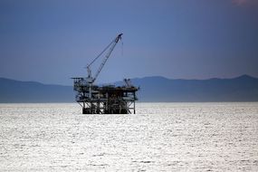 加利福尼亚州亨廷顿海滩附近的油钻平台，卡塔利娜岛在背景“width=