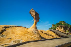 女王的头在Yehliu Geopark，雕刻后面的明亮的蓝天和下面的木板走道