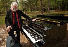 查克·莱维尔（Chuck Leavell）和钢琴在树上“width=