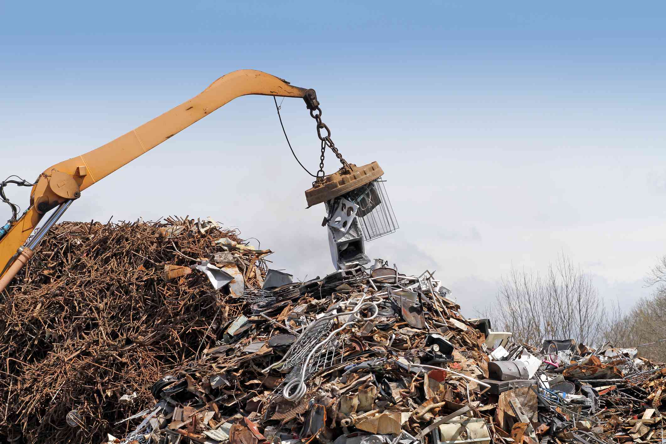 废物管理，起重机将废金属堆在一起，准备运往回收设施＂width=