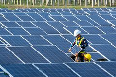 队电工安装太阳能电池板在替代能源清洁工作。