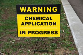 Warning: Chemical application in progress' sign in a lawn