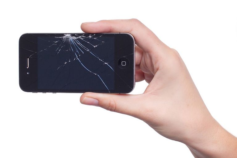 拿着一个破碎的iphone显示的手