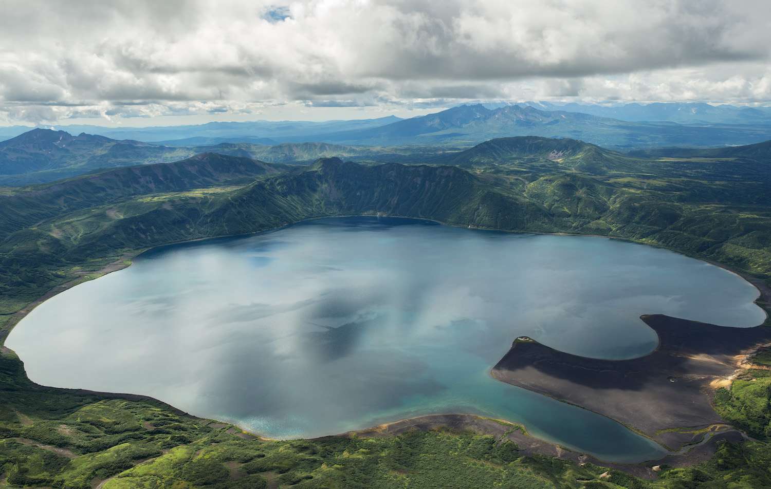 多云的天空，俯瞰地平线上群山环绕的卡里姆斯基湖。