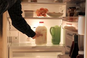 男子将玻璃牛奶放入冰箱