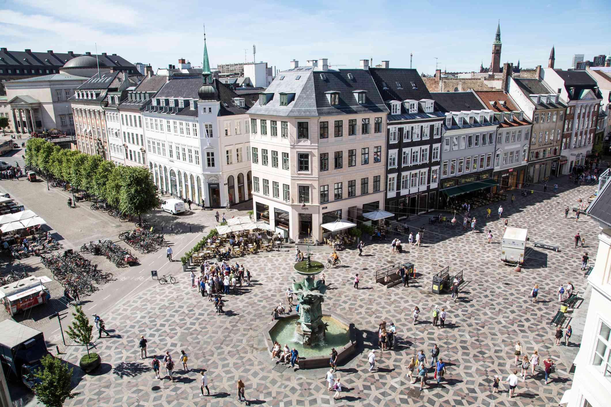 鸟瞰哥本哈根斯特尔格特的购物区，宽阔的装饰性瓷砖走道环绕着绿色喷泉
