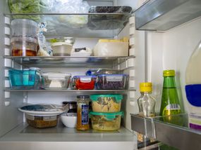 冰箱门打开，容器里堆满了剩菜剩菜