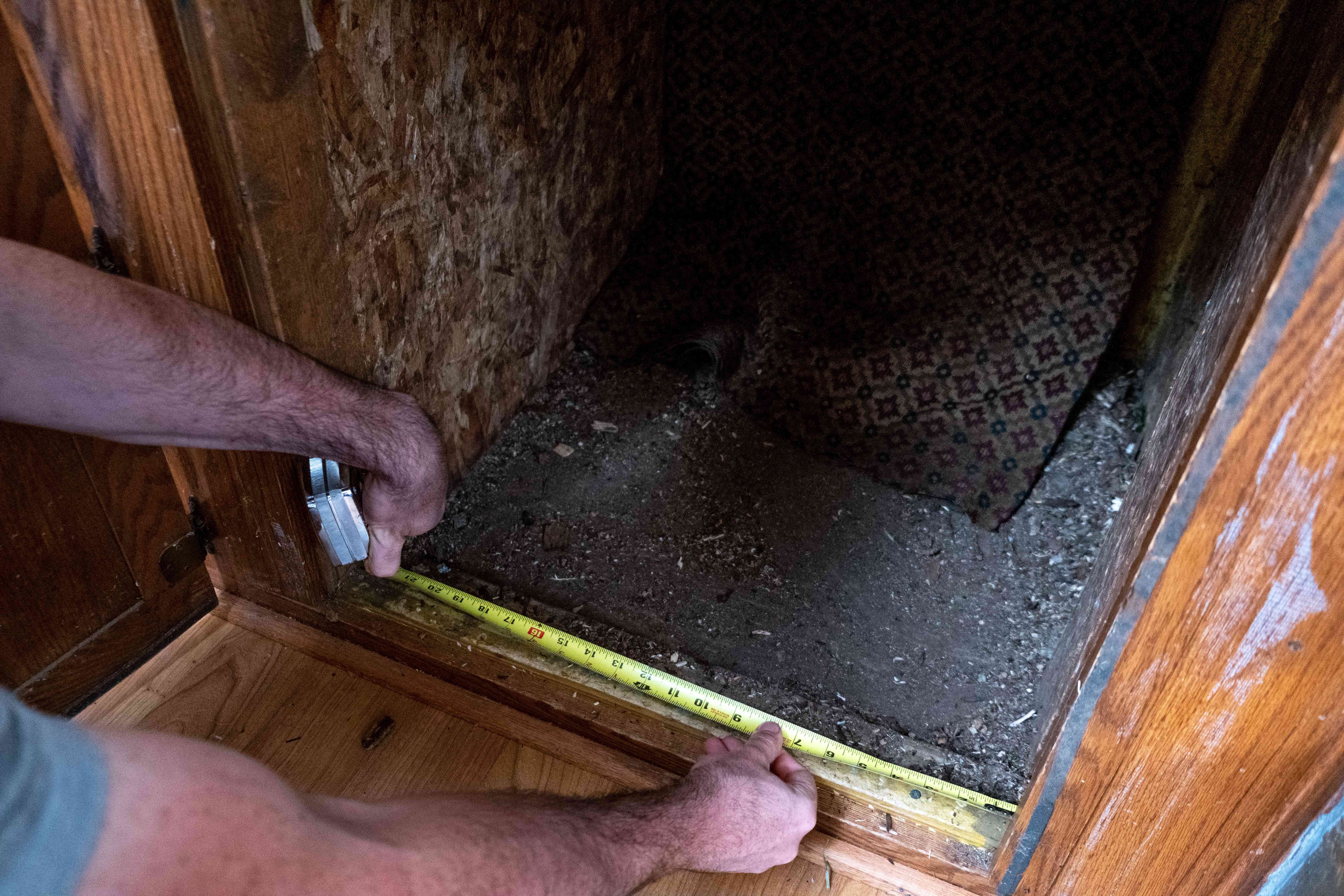 人们蹲下用卷尺测量蚯蚓堆肥系统的柜下空间＂width=
