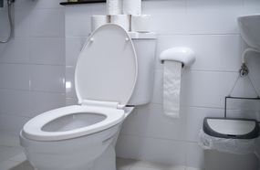 白色无菌浴室的厕所。“width=