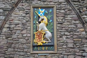 苏格兰国旗上的独角兽，石墙上金色的红狮纹章＂width=