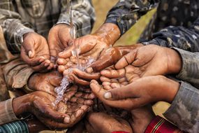 非洲儿童将手在水下杯。“width=