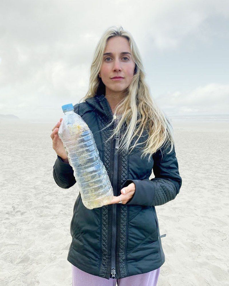 咪咪控股塑料瓶在海滩