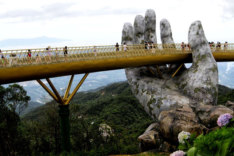 越南岘港附近的金色Cau Vang大桥似乎是由一只巨大的石头手支撑着的