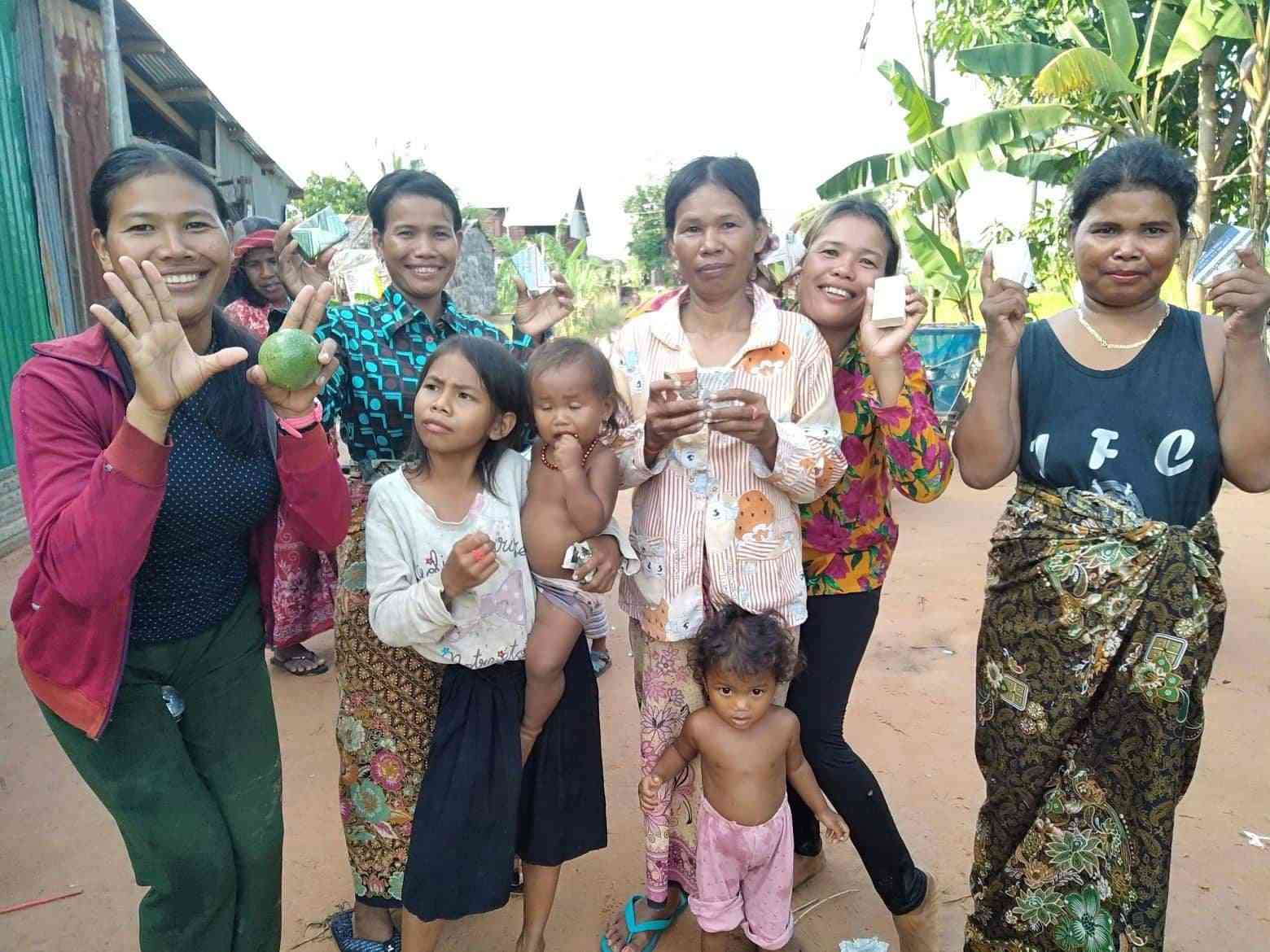 妇女和儿童在柬埔寨带新捐赠的肥皂摆姿势