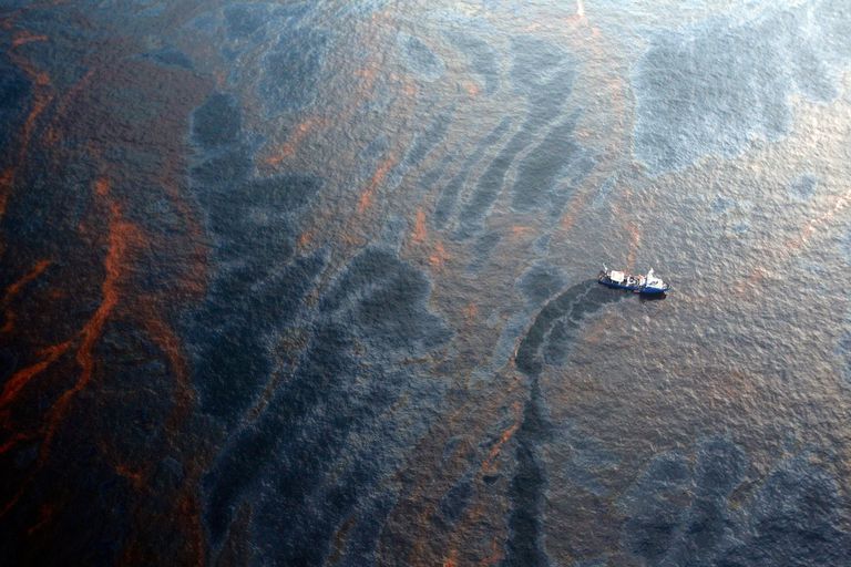 2010年4月28日，路易斯安那州新奥尔良附近，一艘船正在收集墨西哥湾“深水地平线”钻井平台泄漏的石油。＂class=