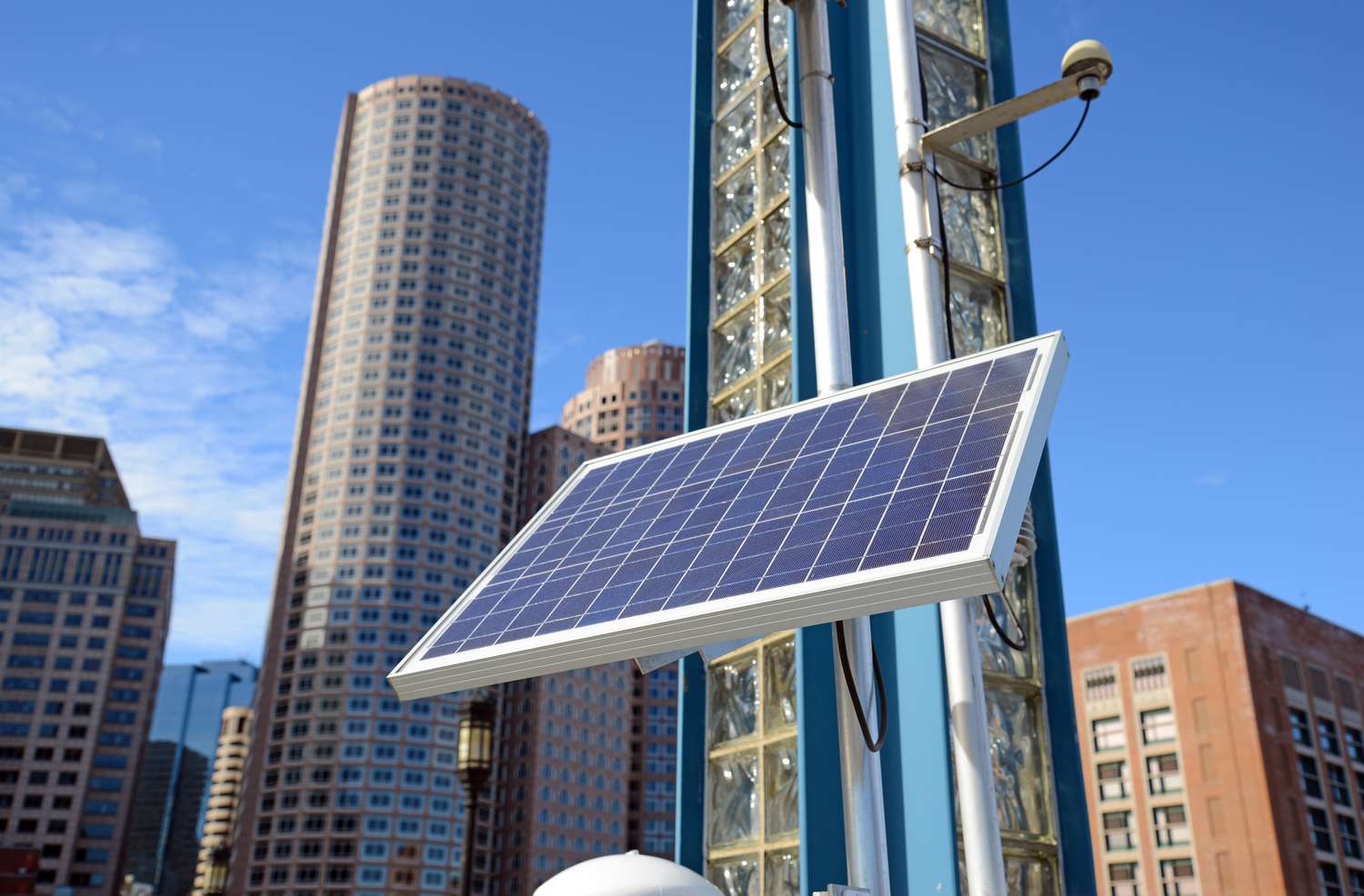 城市景观中的太阳能电池板，衬着蓝天。