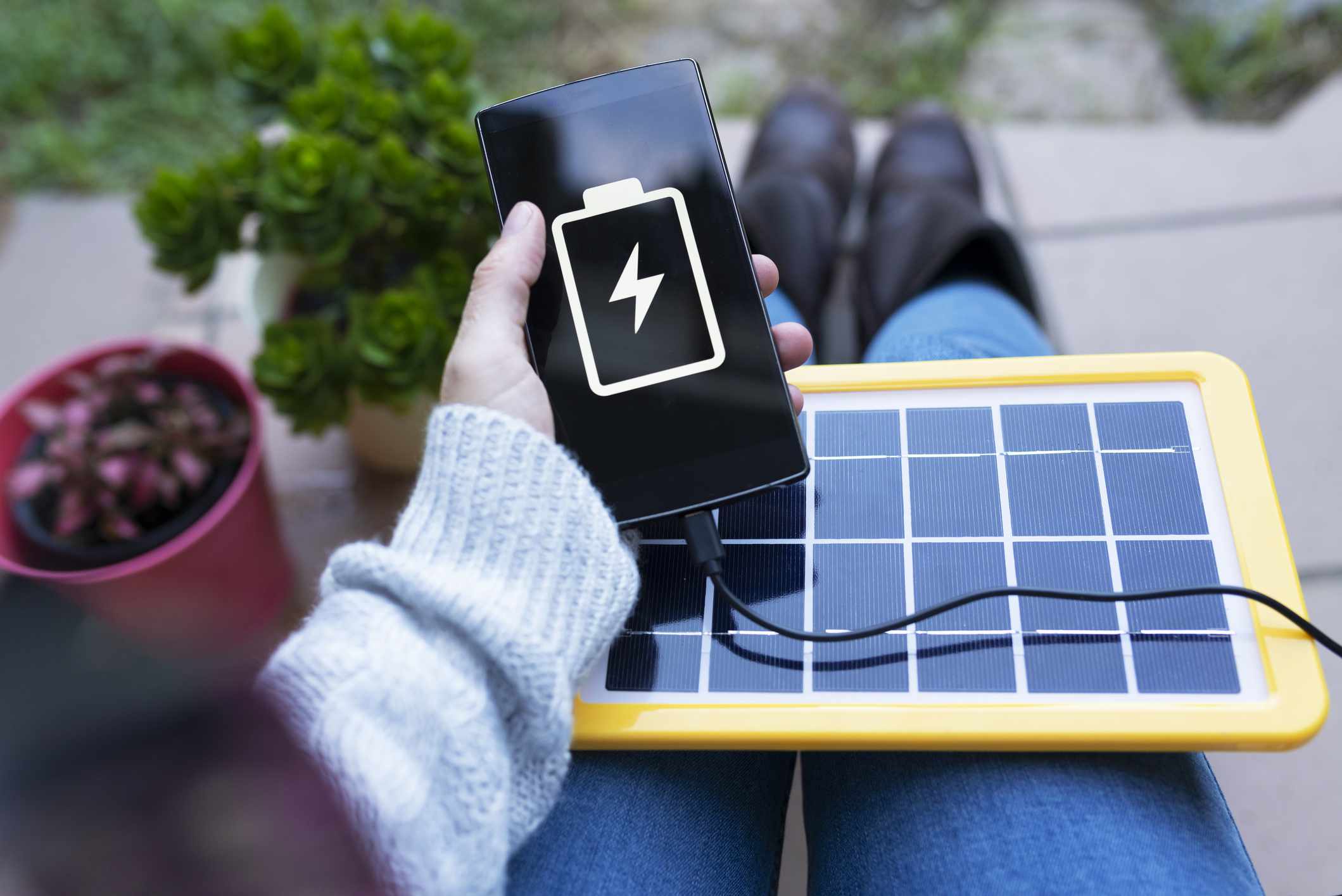 一个平板大小的便携式太阳能设备为智能手机供电。＂width=